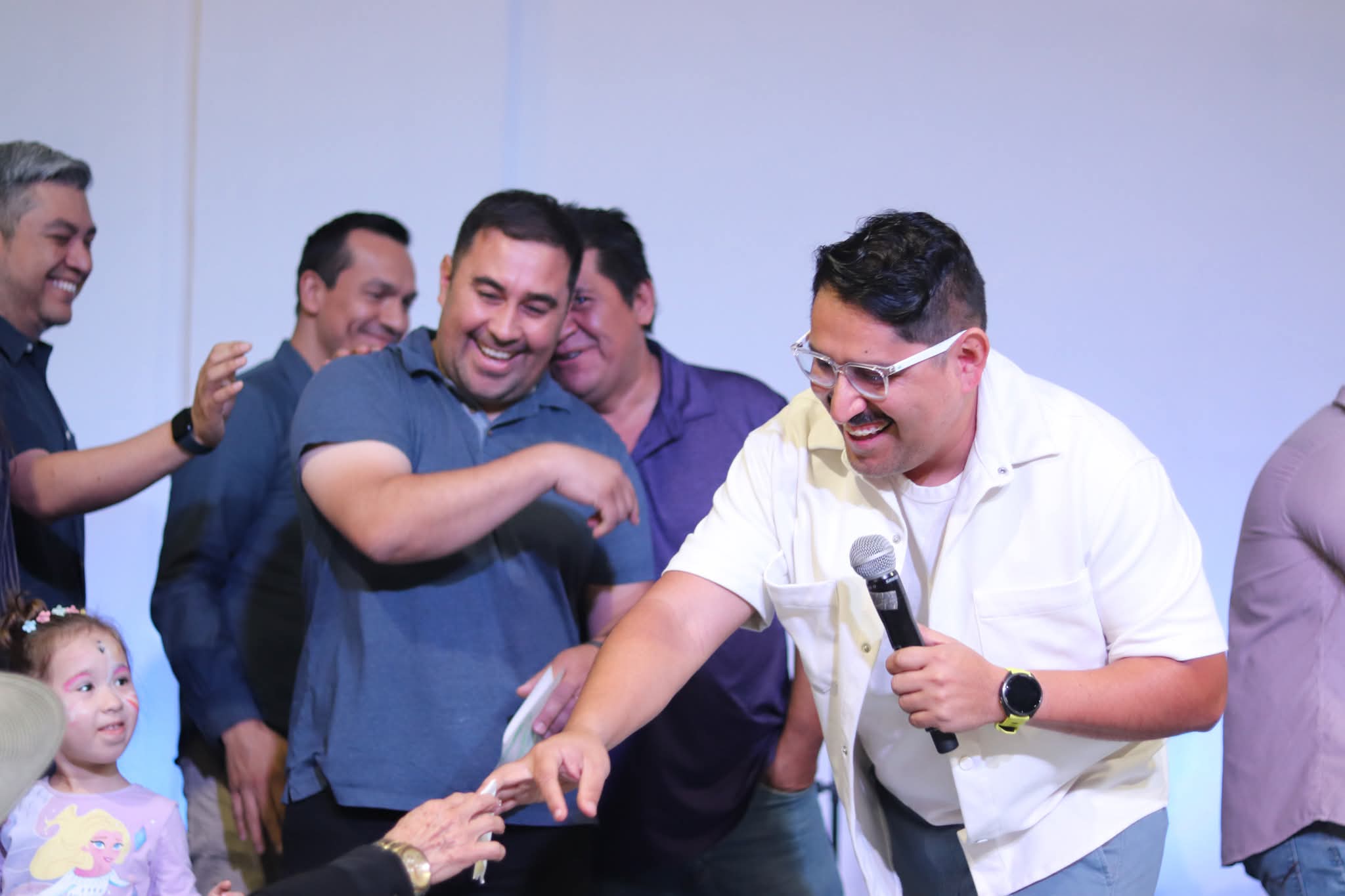 Hombres riendo y dando la mano en el escenario